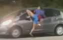Ladrão fica pendurado em janela de carro após tentar roubar celular (veja o vídeo)